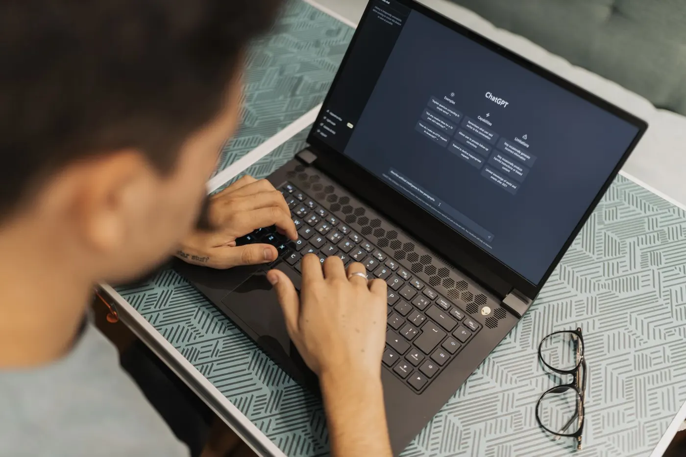 Person typing on a laptop with an AI chat assistant open on the screen