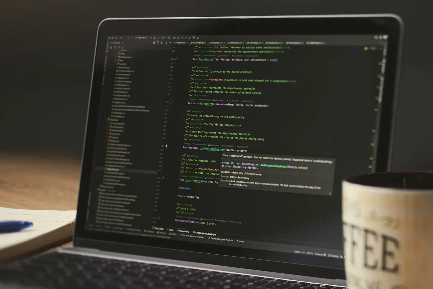 Laptop showing code in an editor on a desk