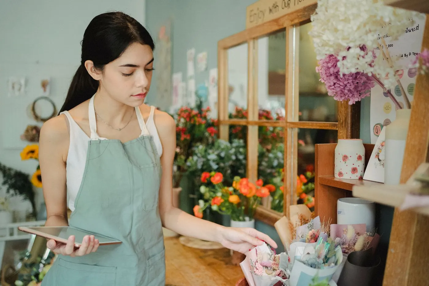 Florist checking orders on a tablet in her flower shop