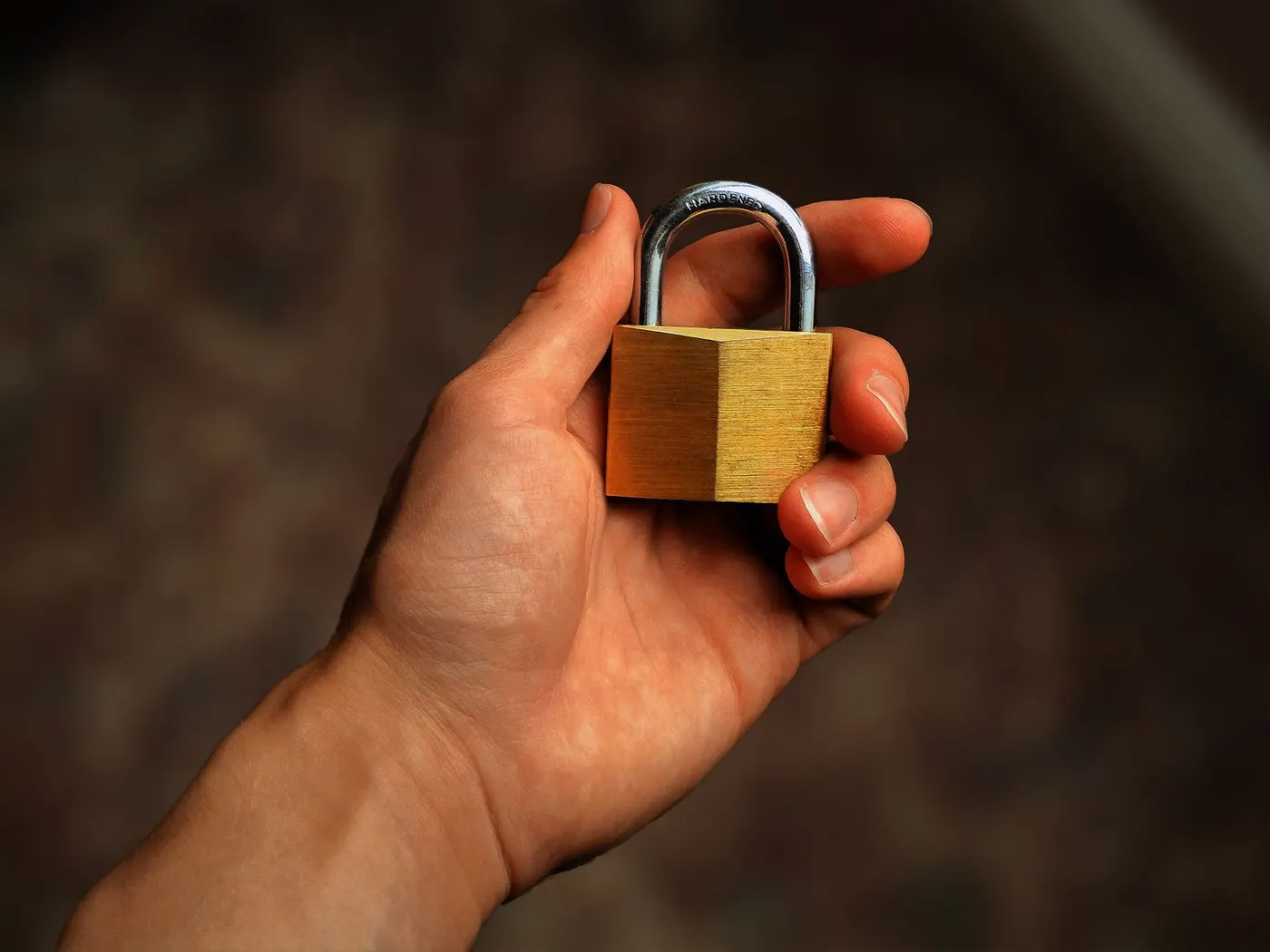 Hand holding a brass padlock